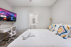 グレンデールにあるElegant Two Bedroom Apartment with Free Parking and Plush Bedsのベッドルーム(白いベッド1台、デスク、テレビ付)