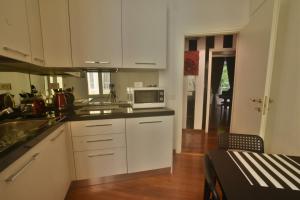a kitchen with white cabinets and a microwave at Piano Suite in Vatican in Rome