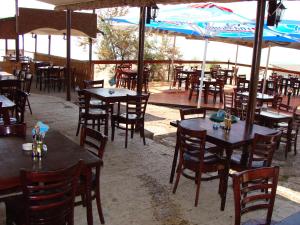 an empty restaurant with tables and chairs and umbrellas at Letovishte Romantika in Kamchia