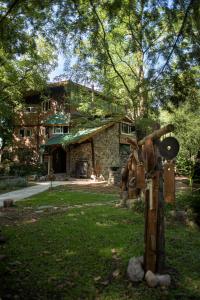a stone house with a statue in front of it at Casitas del arroyo Actividades Arte Cultura y descanso en Villa General Belgrano in Villa General Belgrano