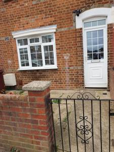 a brick house with a white door and windows at Beautiful house in Reading