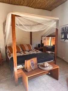 a bedroom with a canopy bed with pillows on it at Case beach in Ngalou Sessène +32 photos