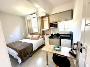 a small room with a bed and a table in it at Ecomarine Apart-hotel 800 m Beto Carrero in Penha