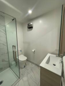 a bathroom with a shower and a toilet and a sink at Chic Auckland Getaway in Auckland