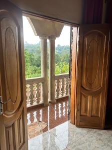 eine offene Tür zu einem Balkon mit Aussicht in der Unterkunft Villa Serena in Bandjoun