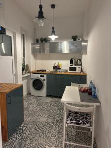 a kitchen with a washing machine and a table in it at CoolKUSH 2U in Bucharest