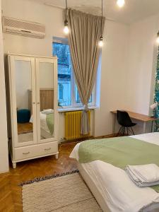 a bedroom with a bed and a large window at CoolKUSH 2U in Bucharest