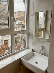 a bathroom with a sink and two windows at CoolKUSH 2U in Bucharest