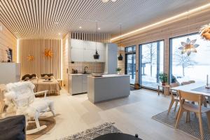 a kitchen and living room with a table and chairs at Scandinavian lakeside cottage in Rovaniemi