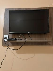 a flat screen tv sitting on a tv stand at Hotel Real in Bom Jesus da Lapa