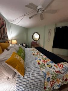 a bed in a room with a ceiling fan at "Summer Winds" at Sunglow Resorts with Spectacular Ocean Views in Daytona Beach Shores