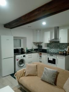 a living room with a couch in a kitchen at petite maison cosy in Auneau