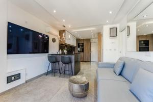 Una sala de estar con un sofá y una cocina. en Hermitage Homes TDS, en Playa de las Américas