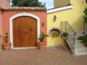 a building with a wooden door and a staircase at Guesthouse Pino in Brtonigla