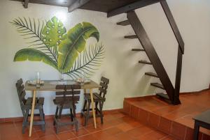a table and chairs with a mural on the wall at Playa Alta Sol in Taganga