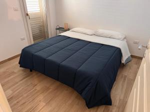 a bed with a blue blanket on top of it at La Casa al mare Torre San Giovanni in Torre San Giovanni Ugento
