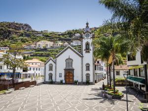 a large white building with a clock tower on a hill at Apartamento Deluxe II RB in Ribeira Brava