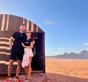 Bedouin Nights Camp في وادي رم: رجل وامرأة يقفان أمام مبنى