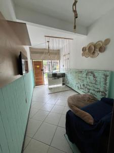 a room with a bed and a hallway with a door at Hostel Preservar in Cabo Frio