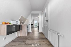 a kitchen with white walls and a wooden floor at Apartment 25 in Kappeln