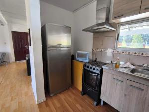 a kitchen with a stainless steel refrigerator and a sink at casa grande 7 personas Piriápolis in Bella Vista +19 photos