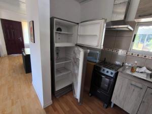 a kitchen with an open refrigerator and a stove at casa grande 7 personas Piriápolis in Bella Vista
