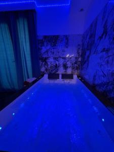 a swimming pool in a room with blue lighting at Studio avec jaccuzzi in Saintry-sur-Seine