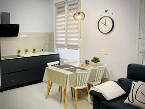 a kitchen with a table and chairs and a clock on the wall at Céntrico estudio en Av Solidaridad in Logroño