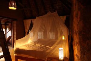 a bedroom with a bed covered in mosquito net at LA LOMA LINDA, Bungalows y Yoga in Zipolite