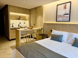 a hotel room with a bed and a kitchen at Mabra Suites in El Calafate