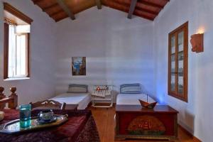 a room with two beds and a table in it at Traditional Cretan Stone House 4 in Kolymvari