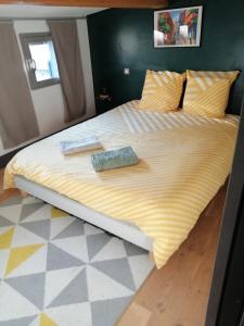 a large bed in a bedroom with a yellow blanket at Maison 2 chambres centre ville in Toulouse