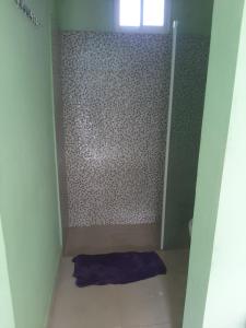 a small bathroom with a shower with a purple towel at Tarde trankila in Sabana de Nisibón