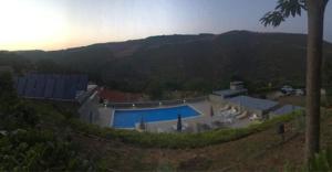 a house with a swimming pool on a hill at Quinta dos Castanheiros - Turismo Rural in Negreda