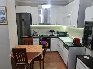 a small kitchen with white cabinets and a table and a tableablish at Tirana Center in Tirana
