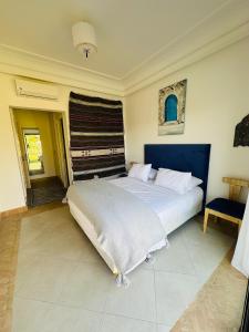 a bedroom with a large bed with a blue headboard at Villa 228 Dyar Shemsi in Taroudant +26 photos