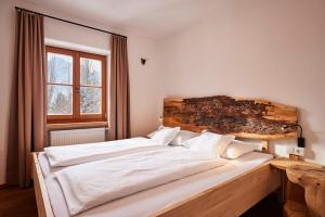 a large white bed in a room with a window at Naturresidenz Mair Zu Hof in Campo Tures