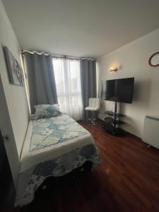a bedroom with a bed and a flat screen tv at Departamentos Santiago Centro # 1005 in Santiago