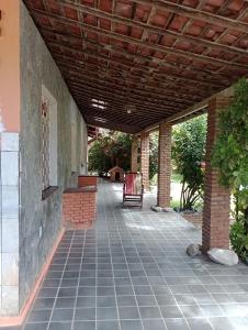 an outdoor patio with awning and chairs on it at Arte e Jardim na Atalaia Nova in Barra dos Coqueiros