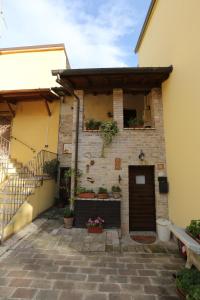 un edificio con porta e fiori in un cortile di B&B La Casuccia Di Assisi ad Assisi