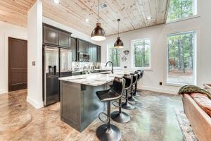 une cuisine avec un grand îlot et des tabourets de bar en cuir dans l'établissement 7 Mi to Broken Bow Lake Wynsome Lodge Cabin!, à Stephens Gap