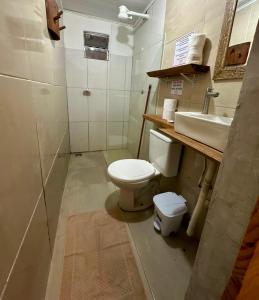 a bathroom with a toilet and a sink at Casa 02 na villa uryah in Caraíva