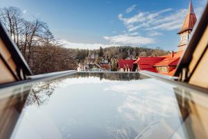 a view from the balcony of a building with a reflection in the water at Apartamenty Przygoda w Karpaczu in Karpacz