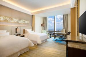 Postel nebo postele na pokoji v ubytování The Westin Jakarta