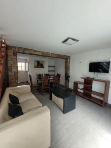 ein Wohnzimmer mit einem Sofa, einem TV und einem Tisch in der Unterkunft Complejo Los Ramones in Valeria del Mar + 61 Fotos