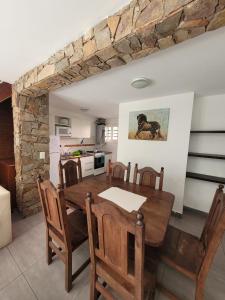 eine Küche und ein Esszimmer mit einem Holztisch und Stühlen in der Unterkunft Complejo Los Ramones in Valeria del Mar