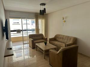 a living room with two couches and a table at Appartement haut standing Mohammedia Parc in Mohammedia
