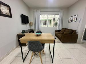 a living room with a table and a couch at Studio no coracao do Kobrasol in São José +7 photos