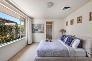 a bedroom with a bed and a large window at Famagusta - Belle Escapes Jervis Bay in Vincentia