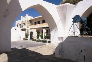 a white building with an archway in front of it at Apollon Hotel in Naxos Chora